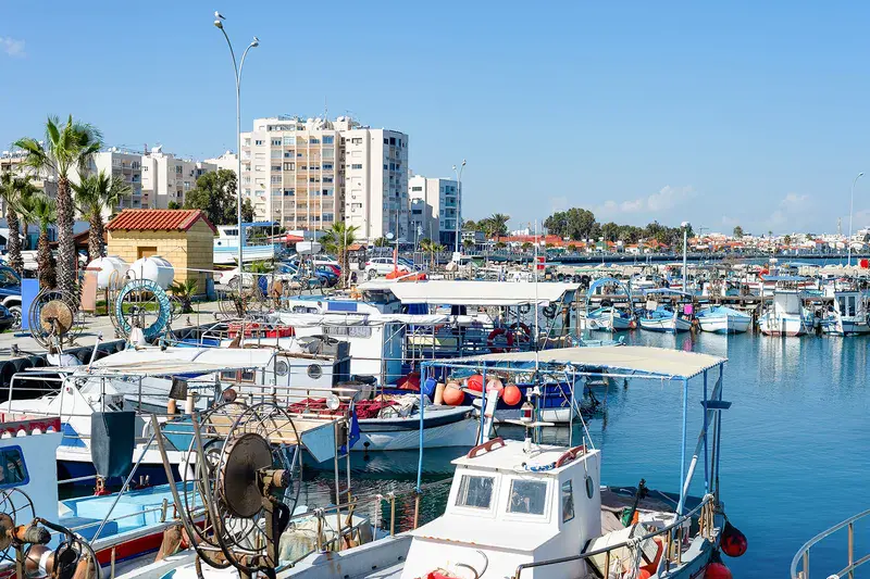 Marina with yachts and cityscape of Larnaca with waterfront apartments in bright sunshine, Cyprus