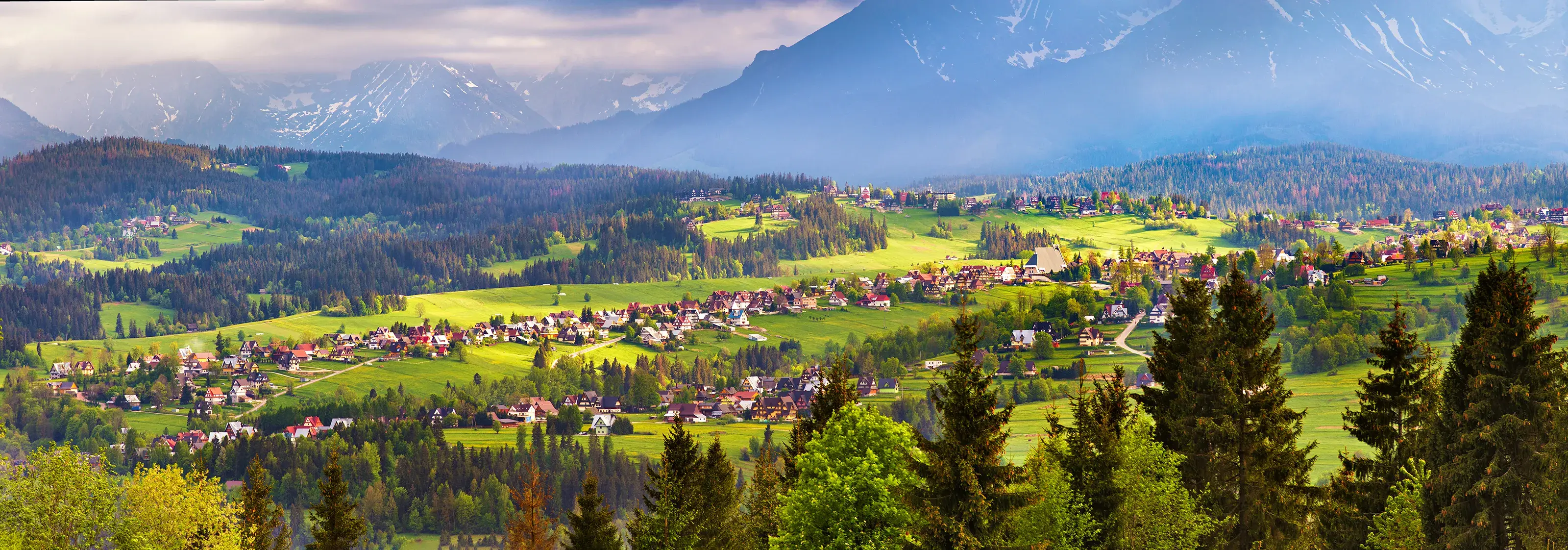 Poland spring Tatra mountains panorama. Malopolska village and green spring meadows on hills. Vacation, travel in Europe. Poland, Zakopane