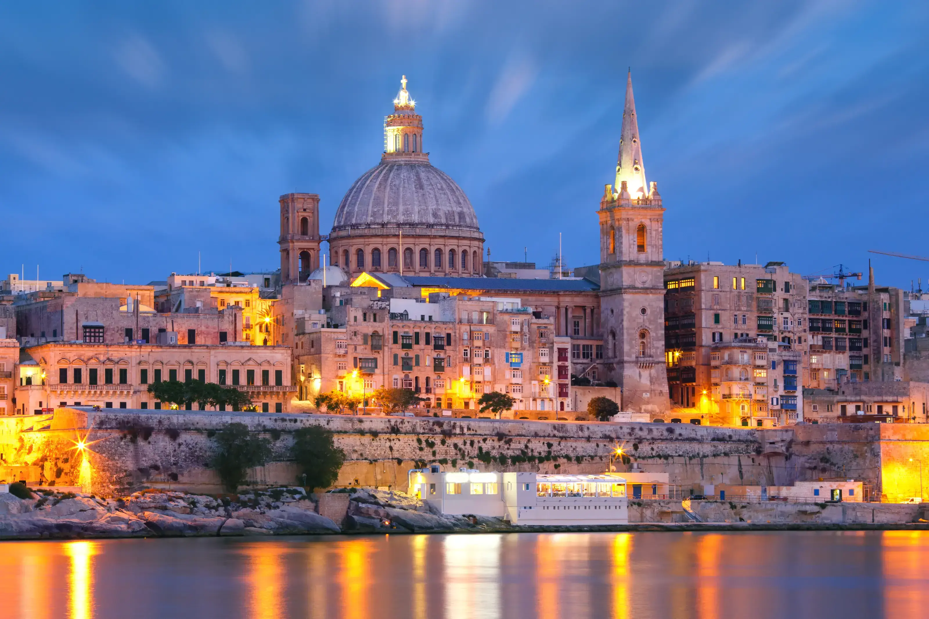 Valletta Skyline from Sliema at night, Malta. Valletta Skyline from Sliema with church of Our Lady of Mount Carmel and St. Paul&rsquo;s Anglican Pro-Cathedral during evening blue hour, Valletta, Capital city of Malta