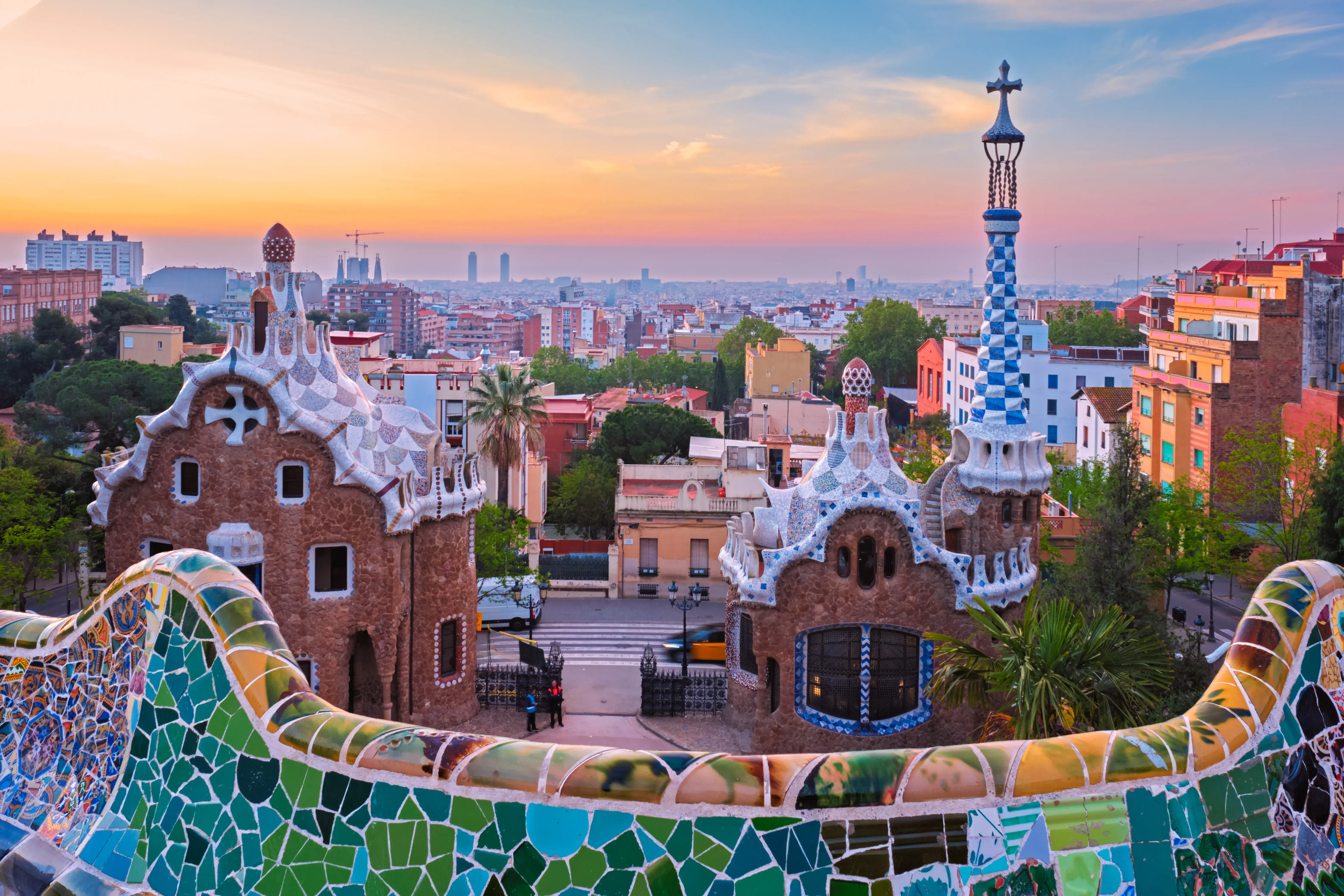 Barcelona city view from Guell Park with colorful mosaic buildings in tourist attraction Park Guell in the morning on sunrise. Barcelona, Spain.
