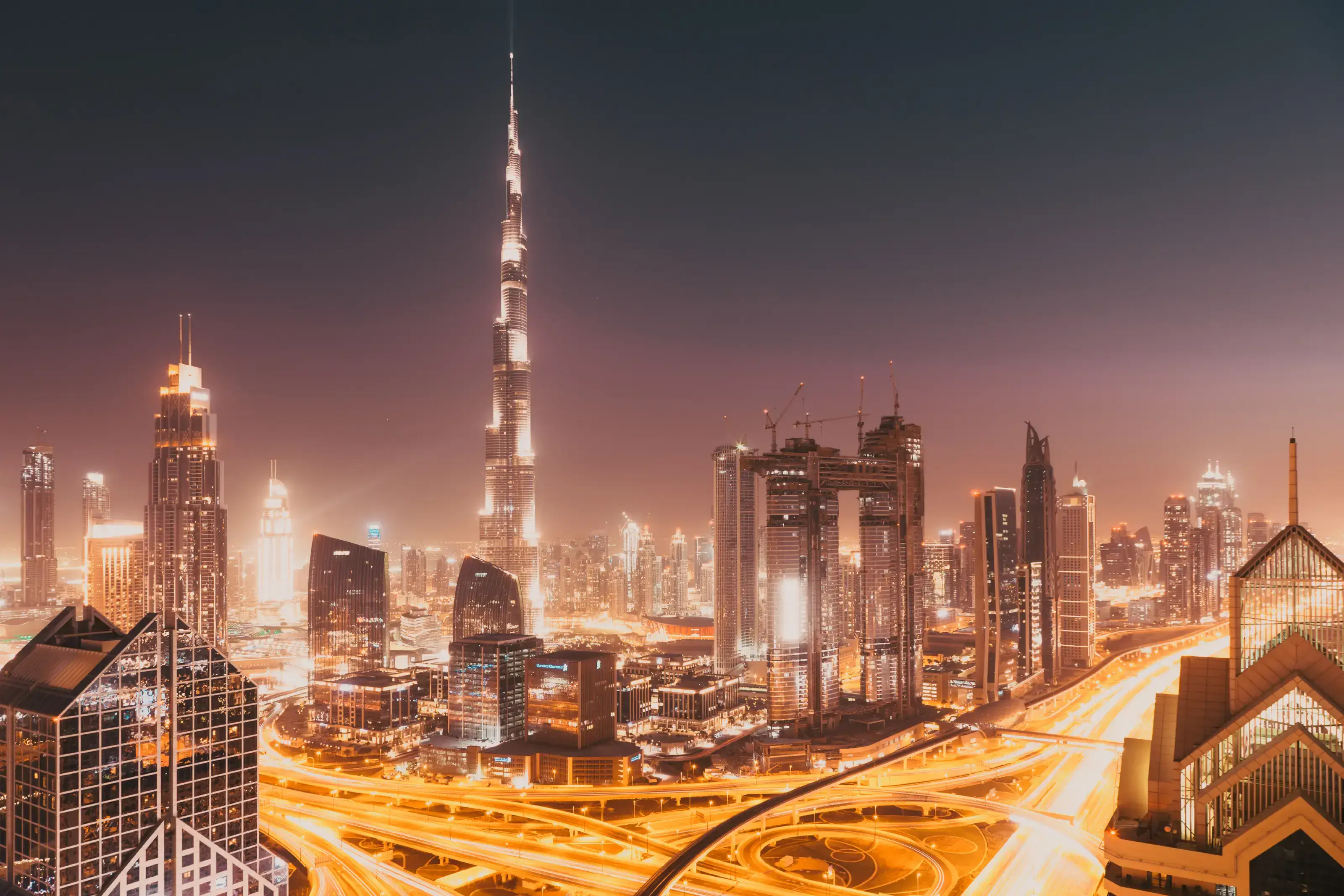 Dubai skyline at sunset with Burj Khalifa, the world tallest building and Sheikh Zayed road traffic